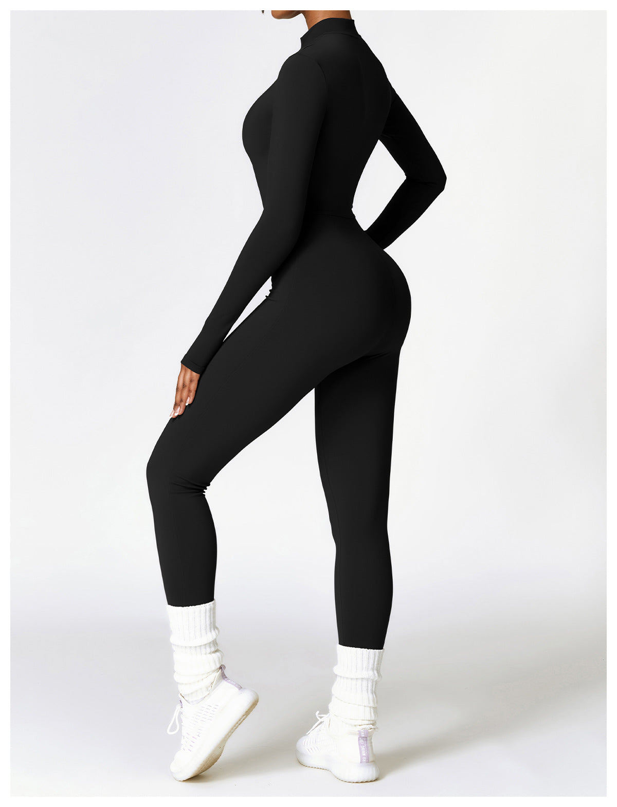 Kvinna i svart långärmad träningsjumpsuit